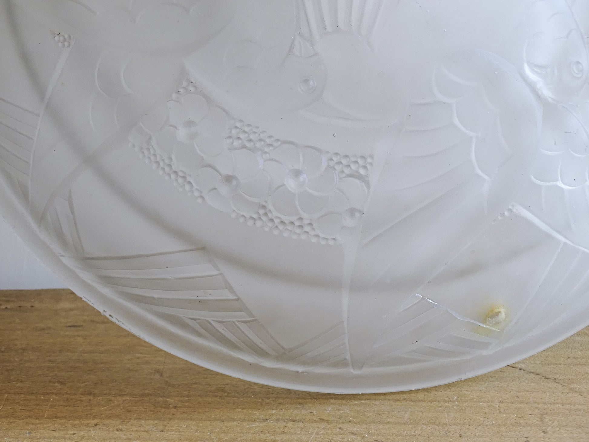Detail of the original fixing hole on a French vintage frosted glass ceiling light shade.