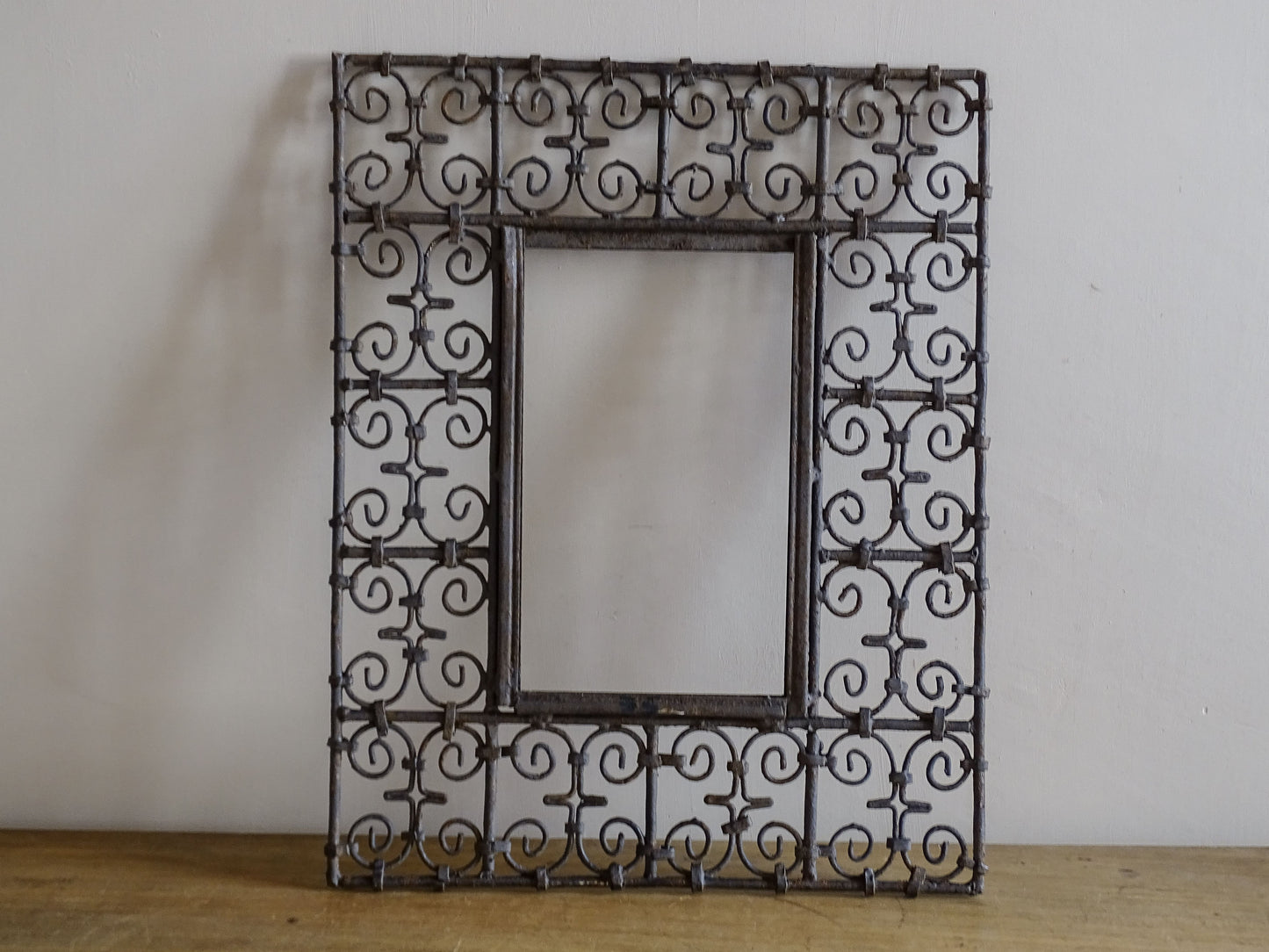 Decorative vintage wrought iron mirror frame with weathered patina