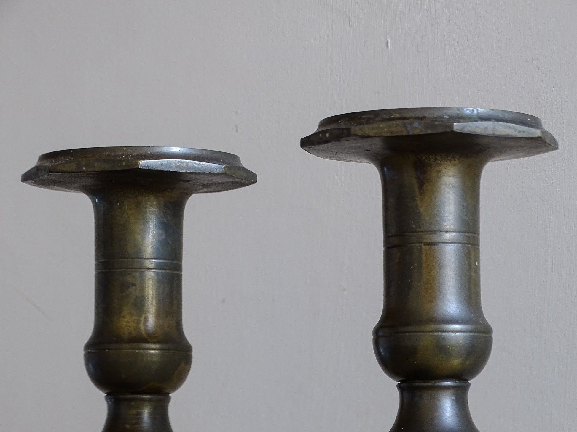 Close-up of the broad candle holders and baluster-shaped tops of antique French candlesticks