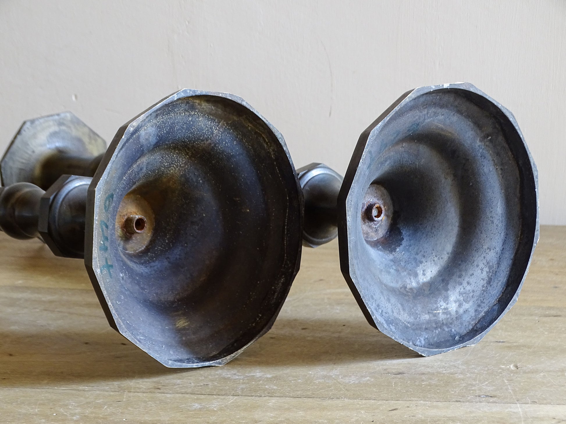 Underside of the octagonal bases on a pair of antique patinated metal candlesticks