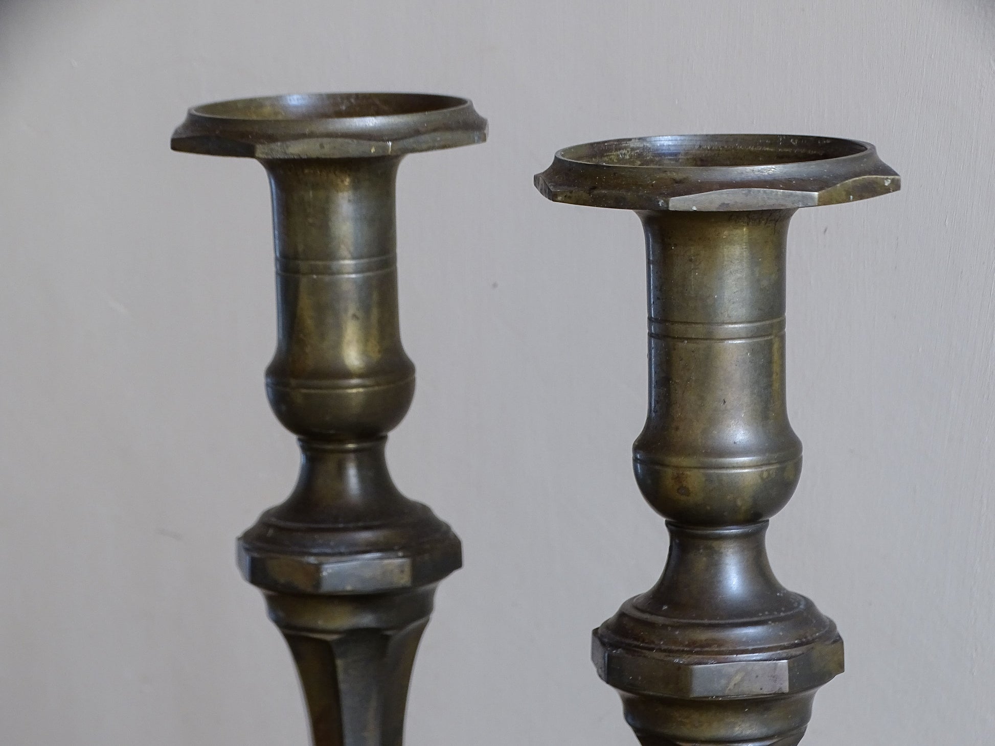 Close-up of the broad candle holders and baluster-shaped tops of antique French candlesticks