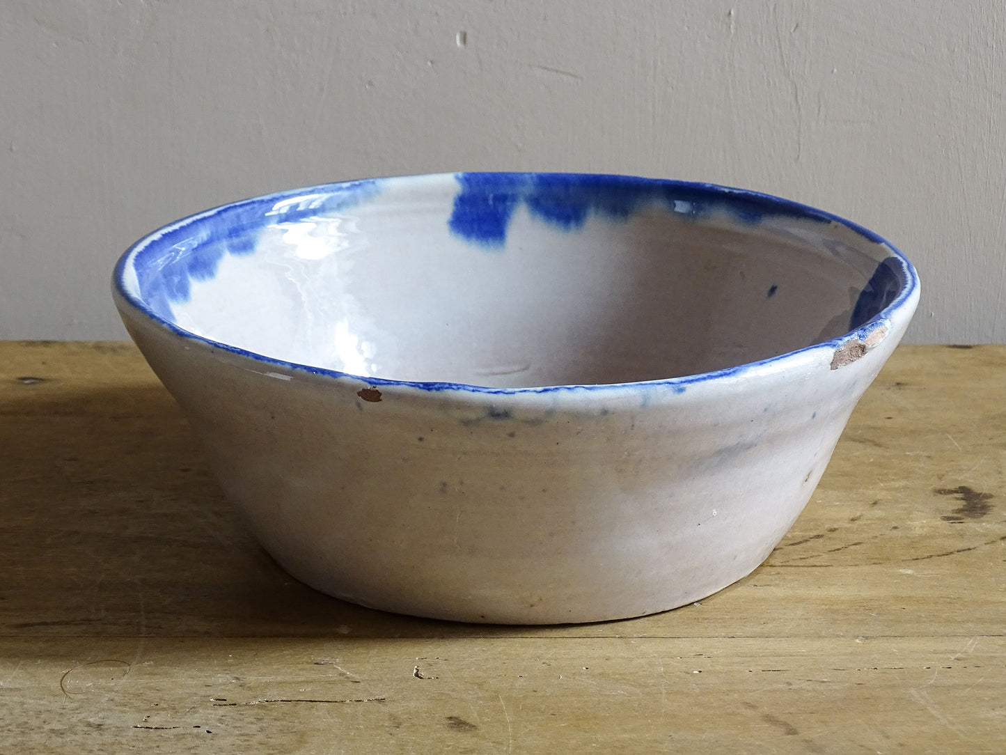 Side view of a vintage Spanish Fajalauza bowl with an irregular hand-thrown shape and cobalt blue