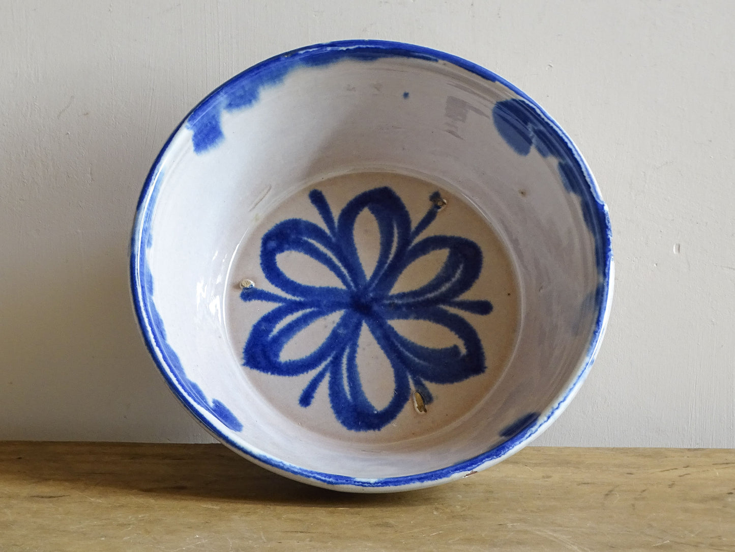Vintage Spanish Fajalauza lebrillo bowl with a cobalt blue floral motif on a creamy white glaze.