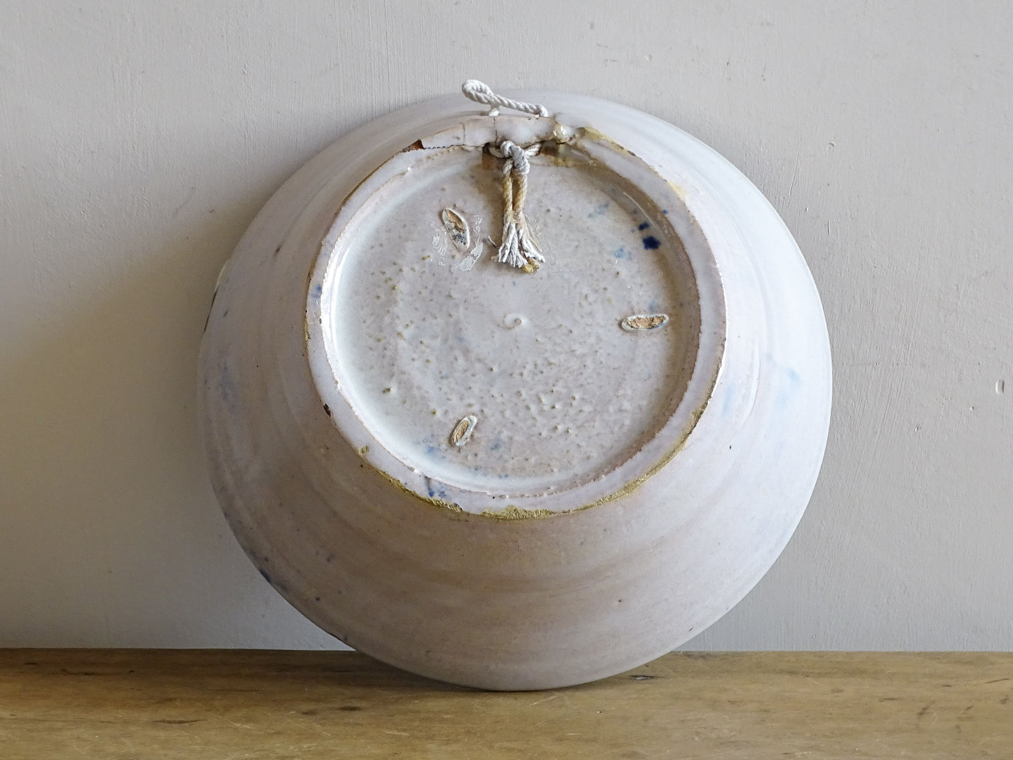 Underside of a Spanish Fajalauza lebrillo bowl showing the foot rim, firing marks and historic damage.