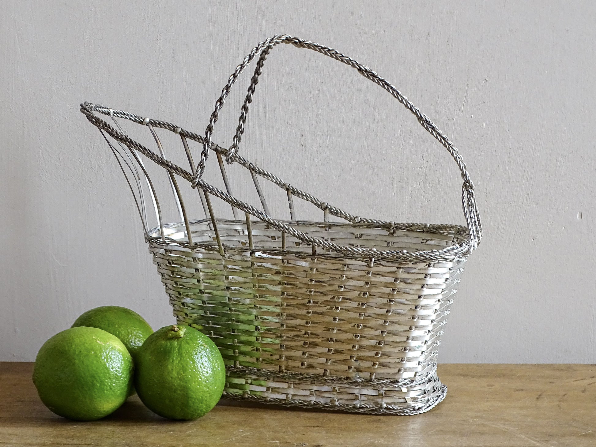 A French vintage silver-tone  woven wire wine basket or bottle carrier. 