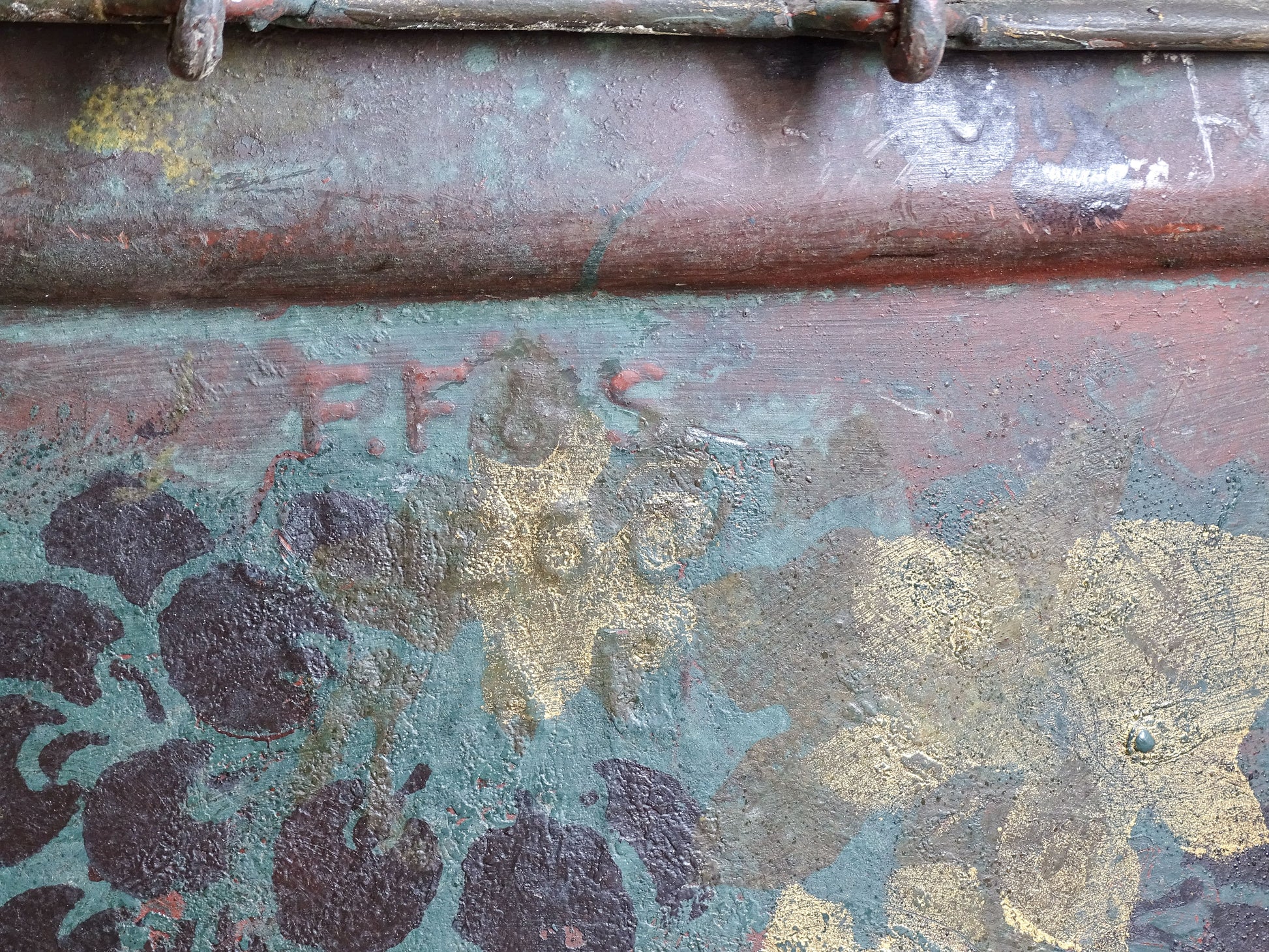 Close-up of the FF&S maker’s stamp among painted grapes and faded gold vine leaves.