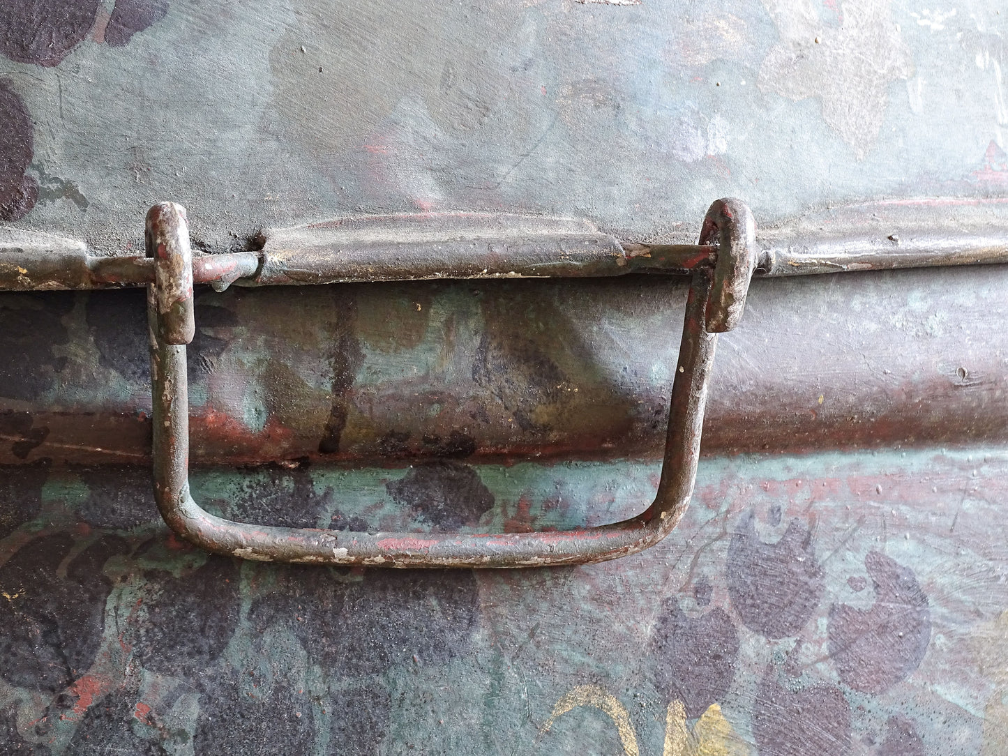 Close-up of the front metal fastening handle with worn paint, oxidation and aged patina.