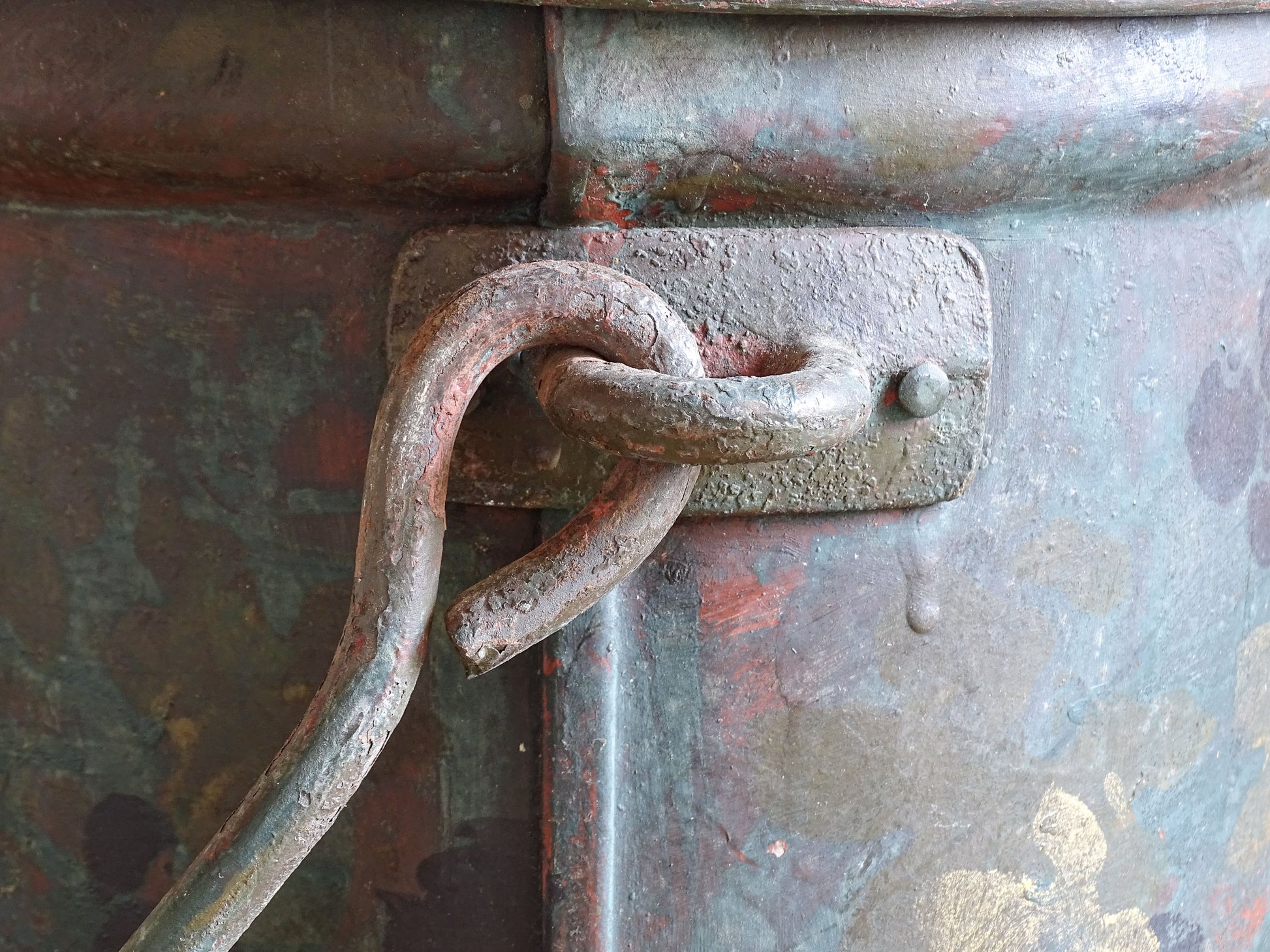 Side view of the lidded painted toleware storage box with a large carrying handle and grape decoration.