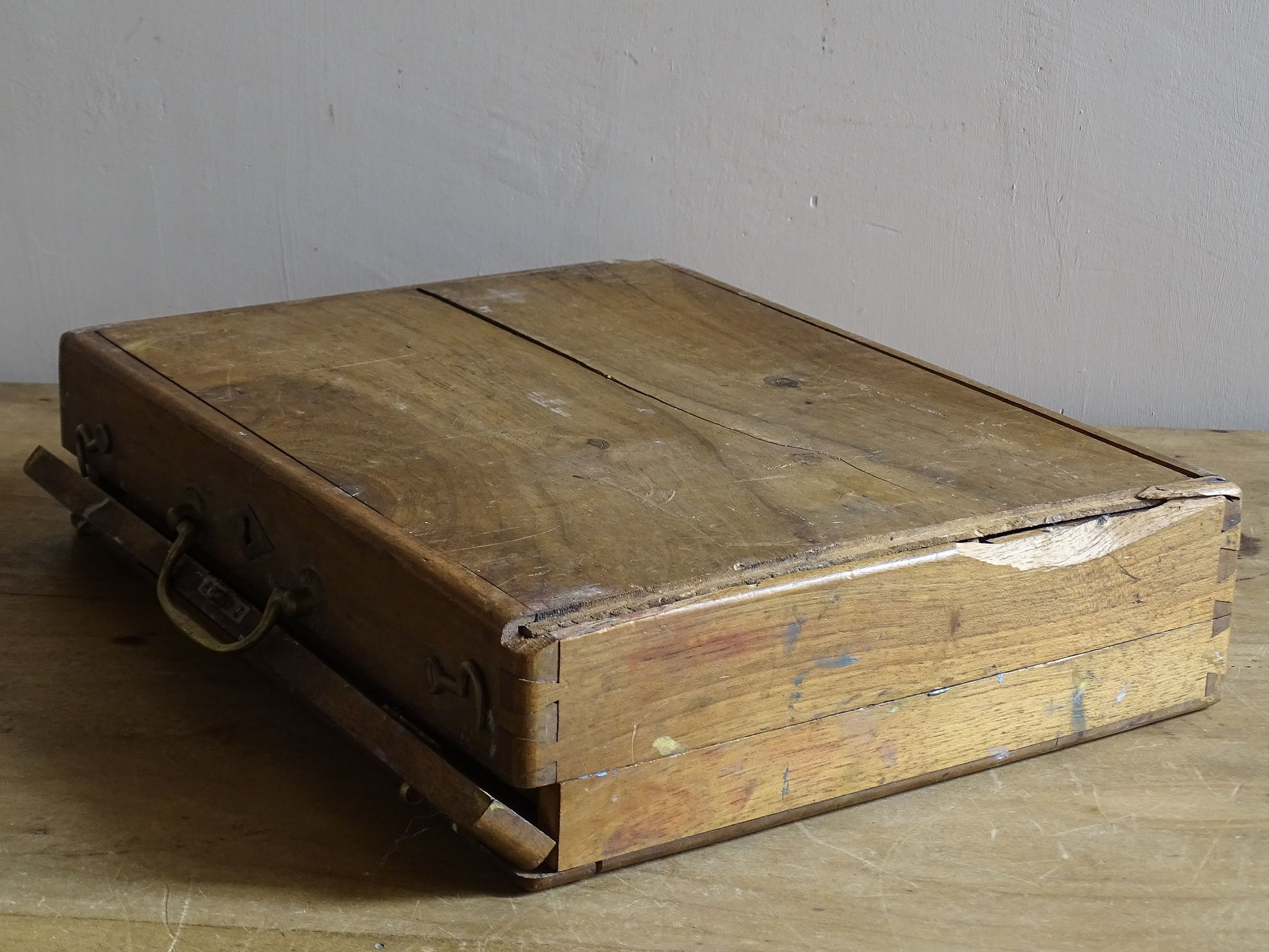 Antique artist’s paint box with aged wood, brass hardware and colourful studio residue