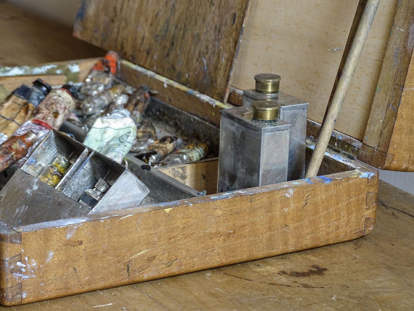 Old French oil paint box with paint-stained interior and artist’s supplies