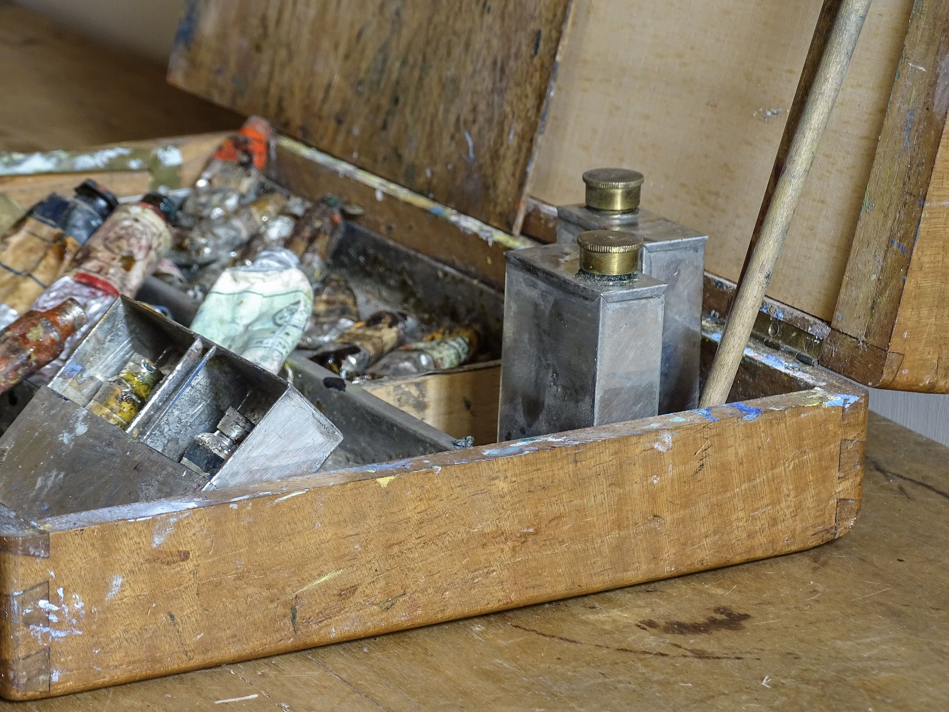 Old French oil paint box with paint-stained interior and artist’s supplies