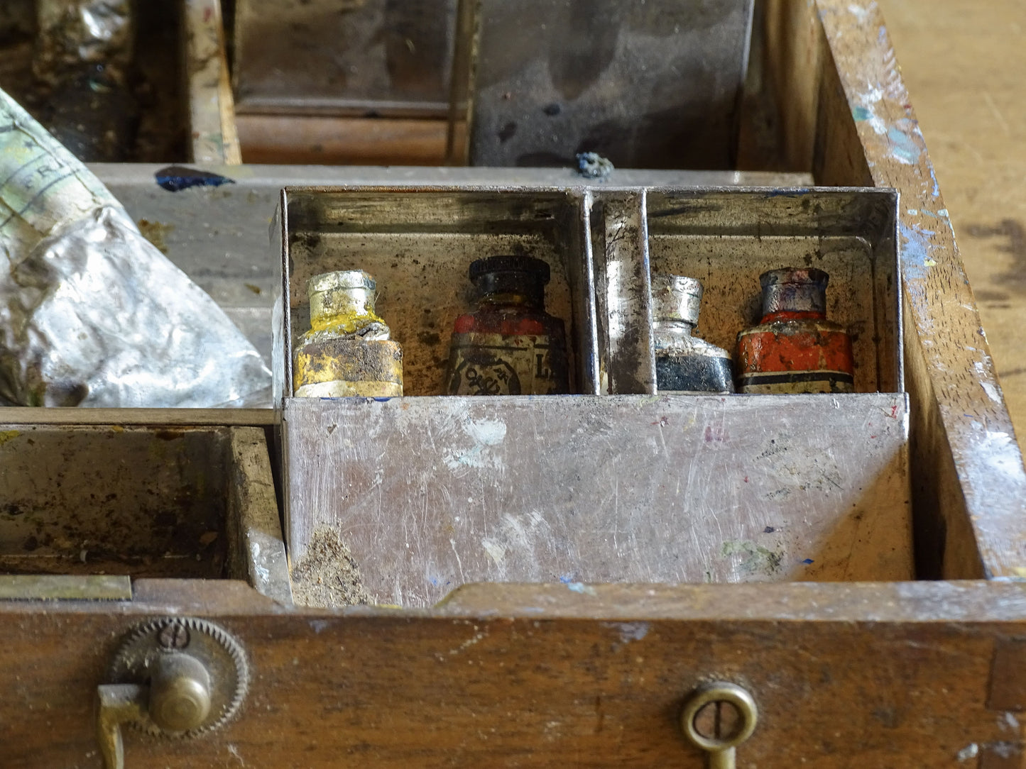 Vintage wooden art box filled with used paint tubes, bottles and brushes