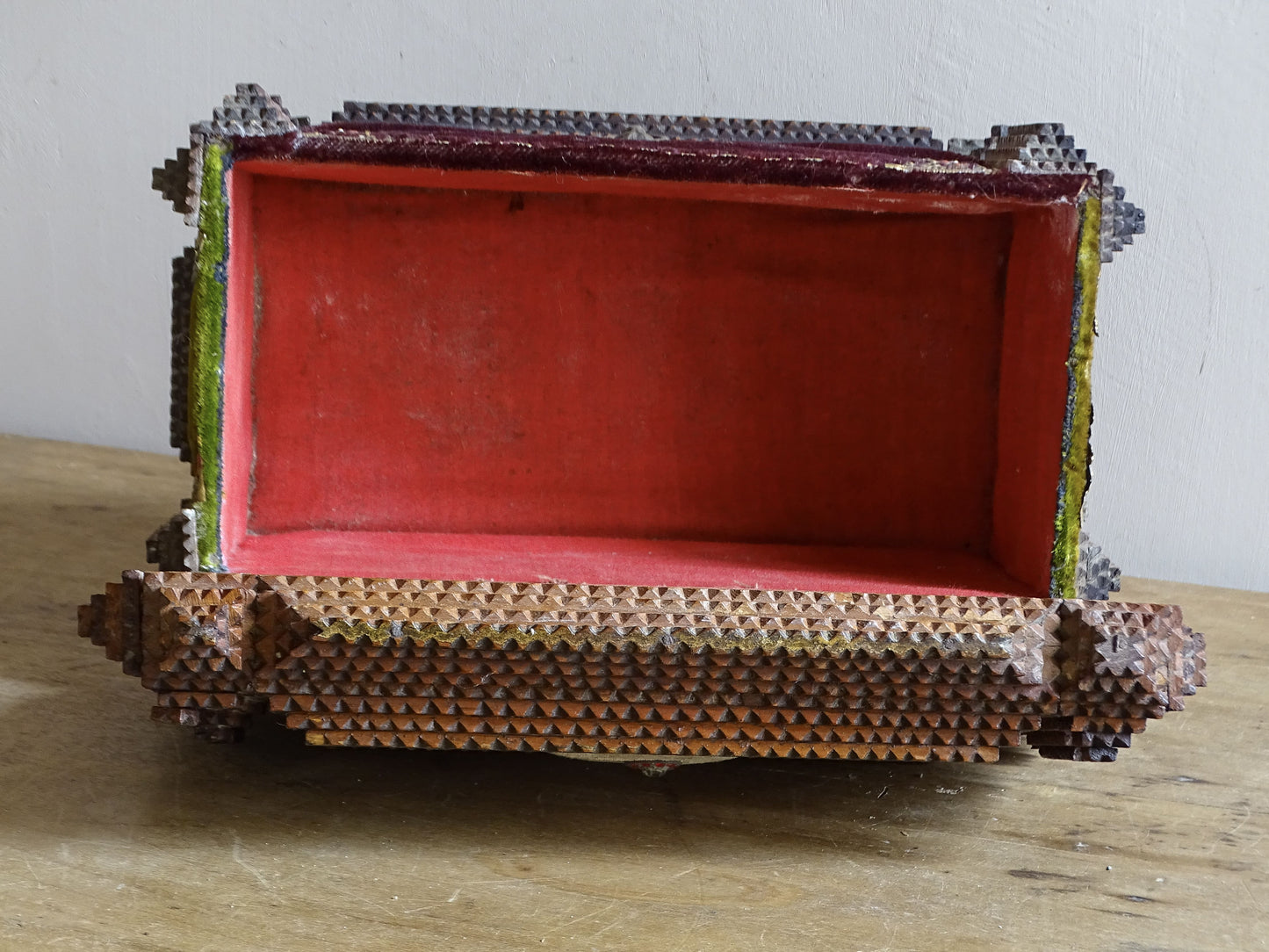 Antique tramp art box opened with a red fabric lining. 
