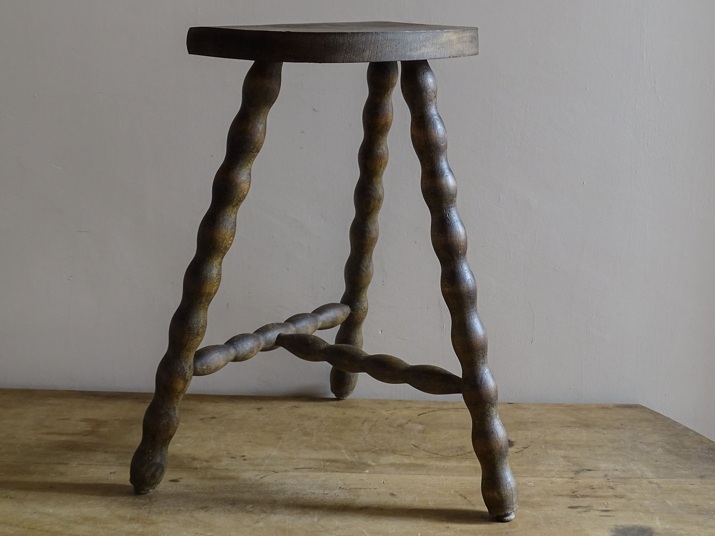 Vintage European wooden stool with an aged brown patina