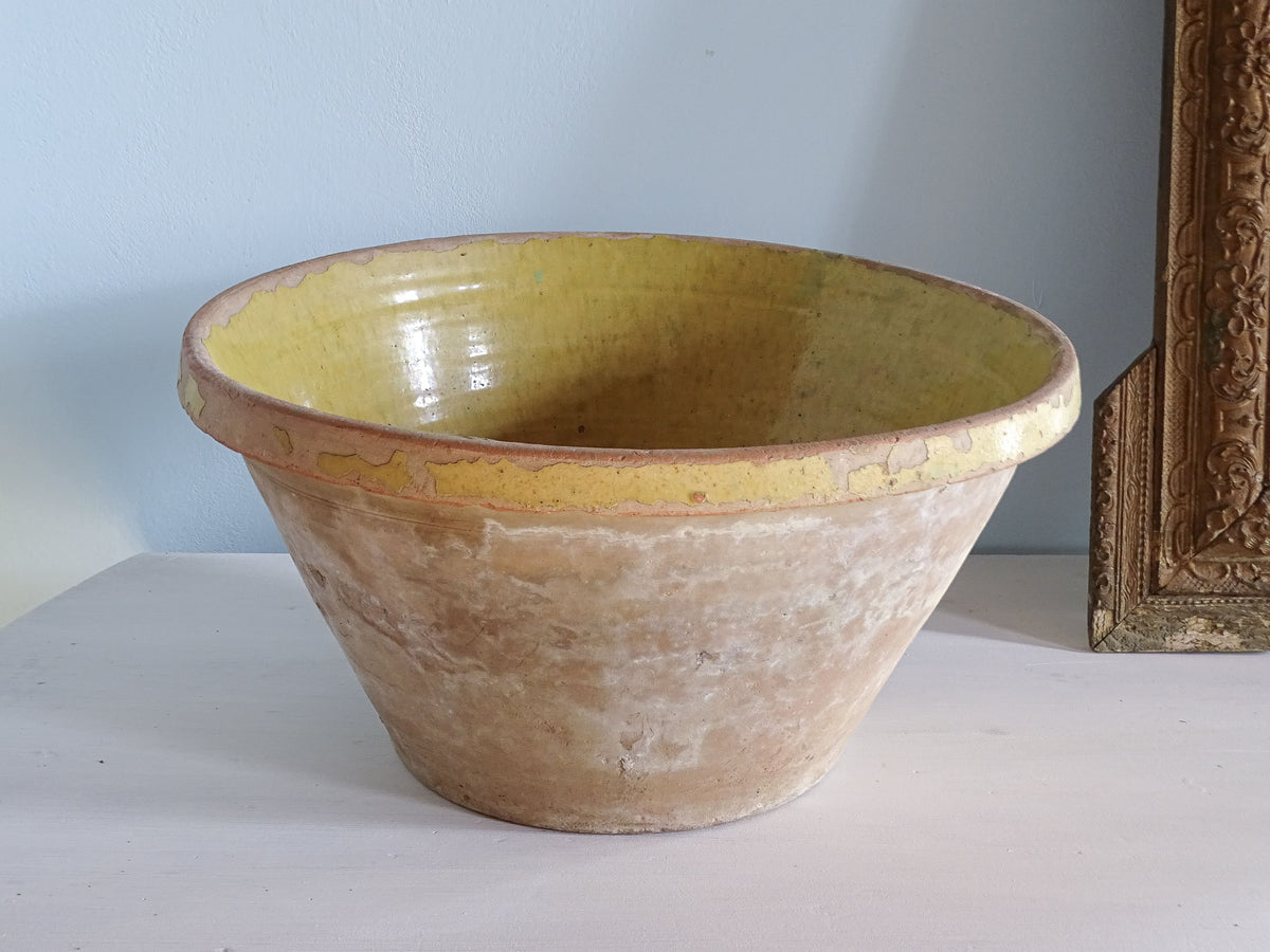 A large rustic French antique tian bowl with yellow glaze