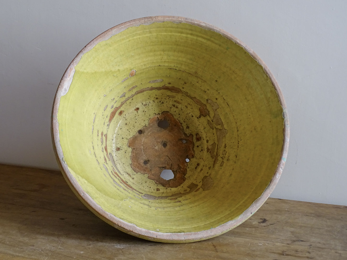 Rustic French pottery tian with aged yellow glaze and weathered surface