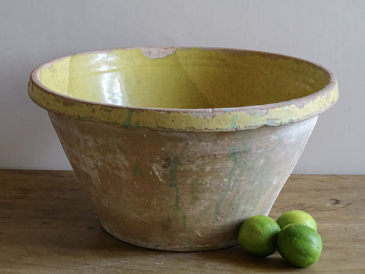 Weathered yellow-glazed French pottery bowl for country interiors