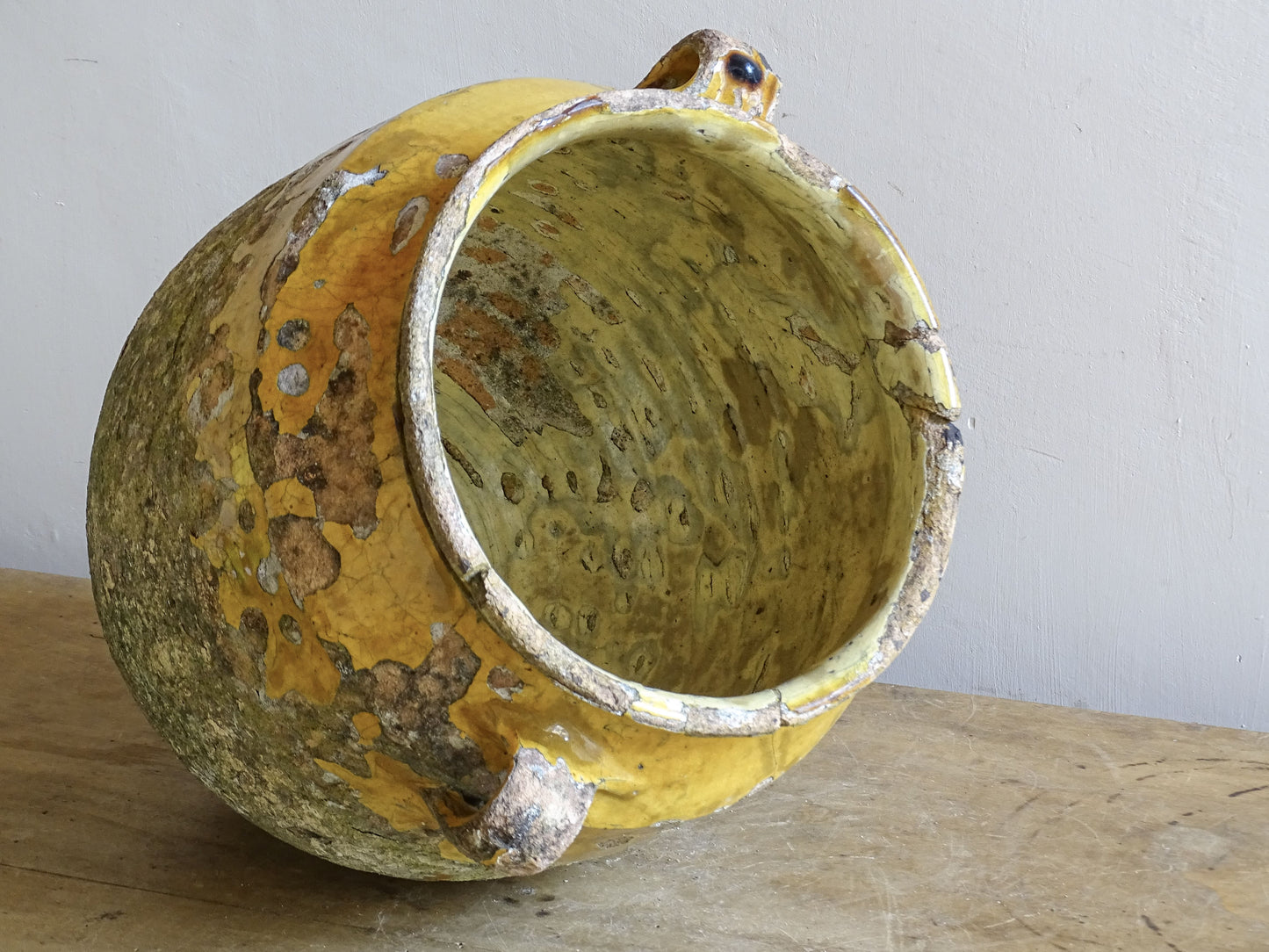 Close-up of chipped rim and aged glaze on antique French earthenware confit pot