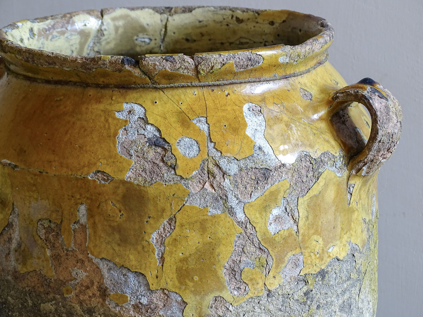 Reverse view of 19th century French confit pot with heavily weathered surface