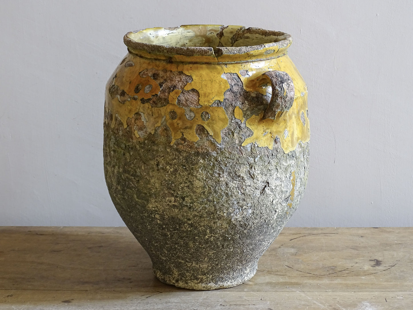Detail of weathered mustard yellow glaze on 19th century French confit pot