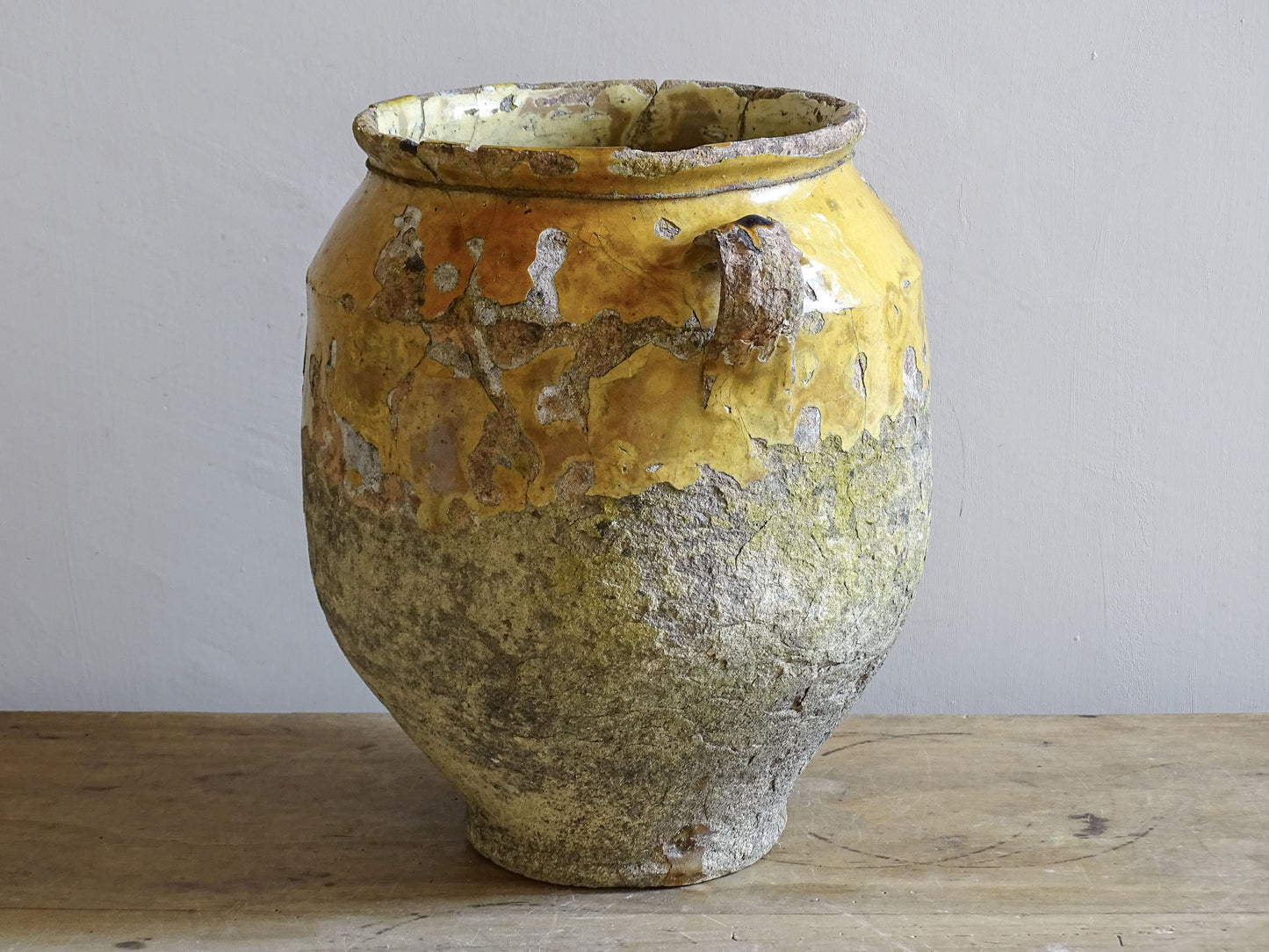 antique French confit pot with a worn yellow glaze 