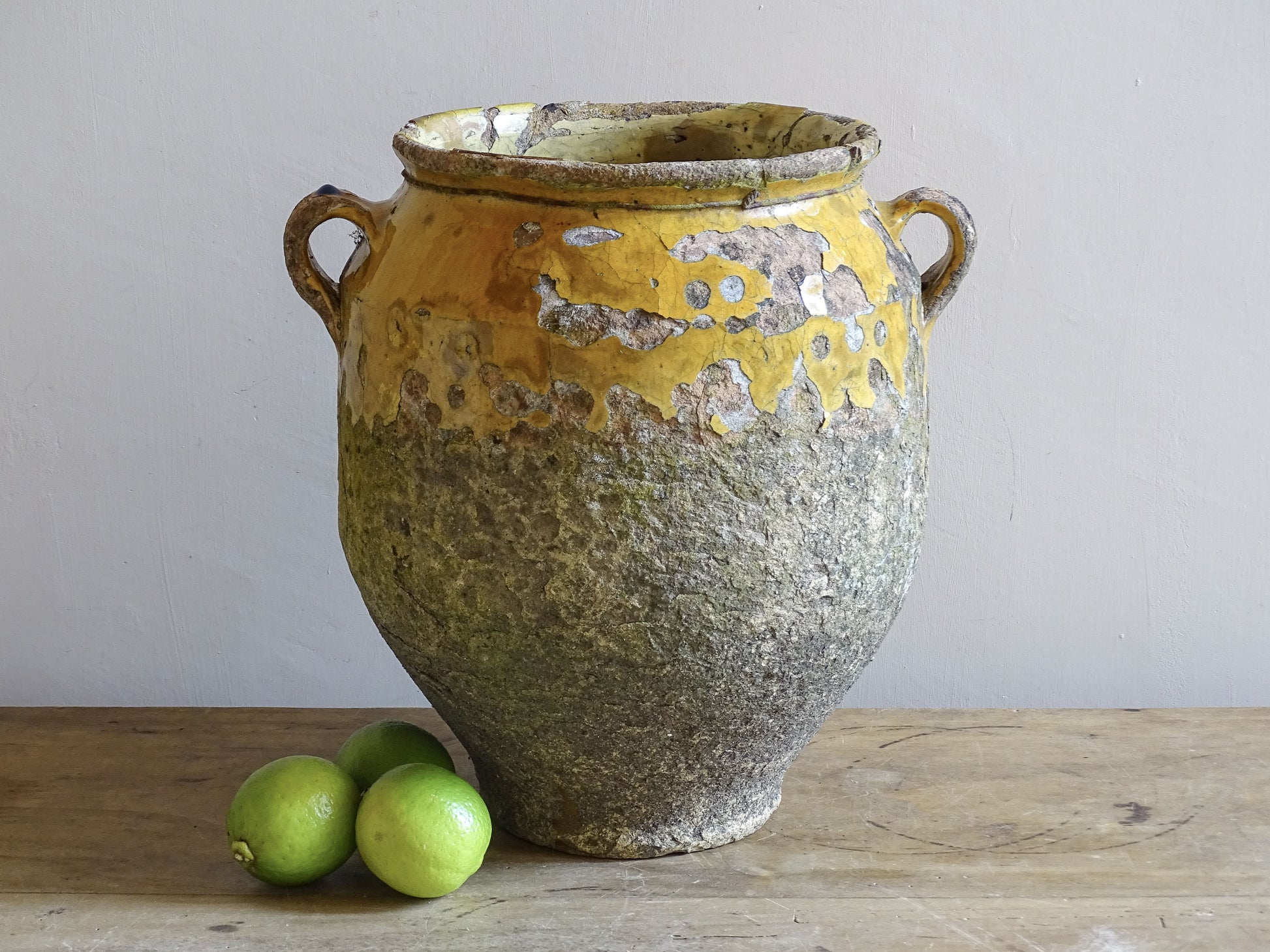 Antique French confit pot with mustard yellow glaze and heavily weathered patina