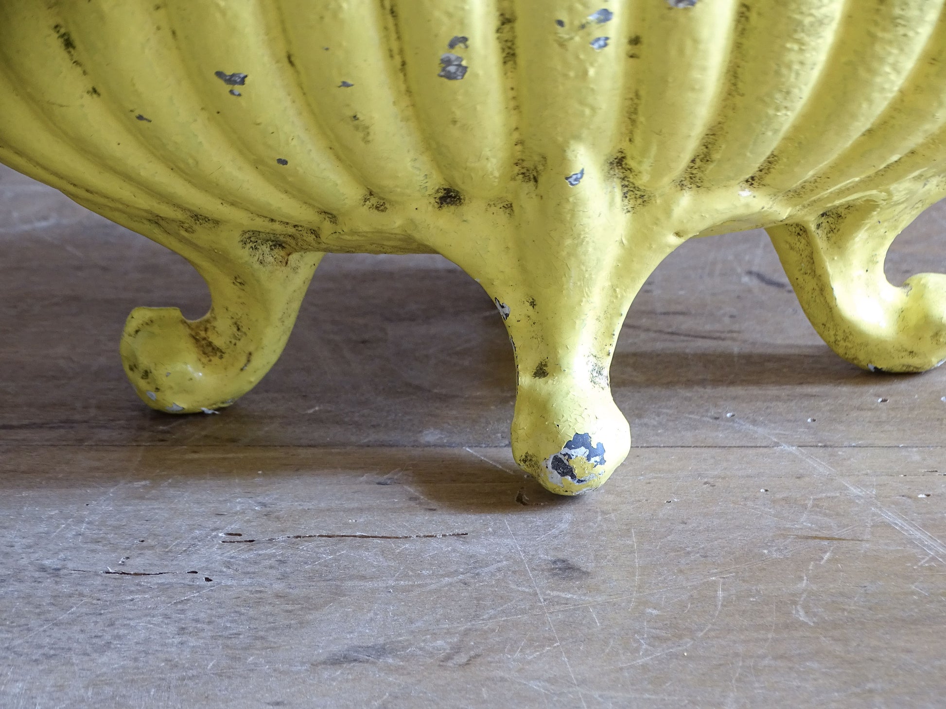 Side view of an antique French yellow cast iron jardinière dating from around 1900.