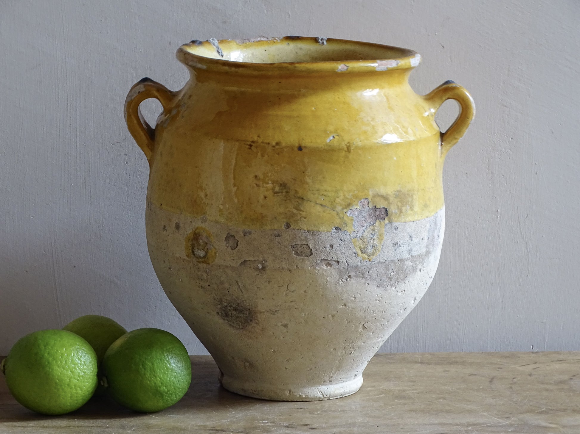An antique French Confit Pot with Yellow Glaze and two looped handles.
