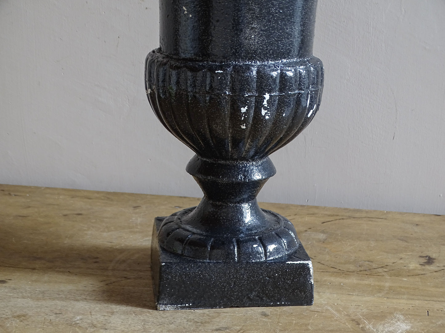 Antique French cast iron Médici urn planter with black painted finish, flared rim, gadrooned detail and square pedestal base.