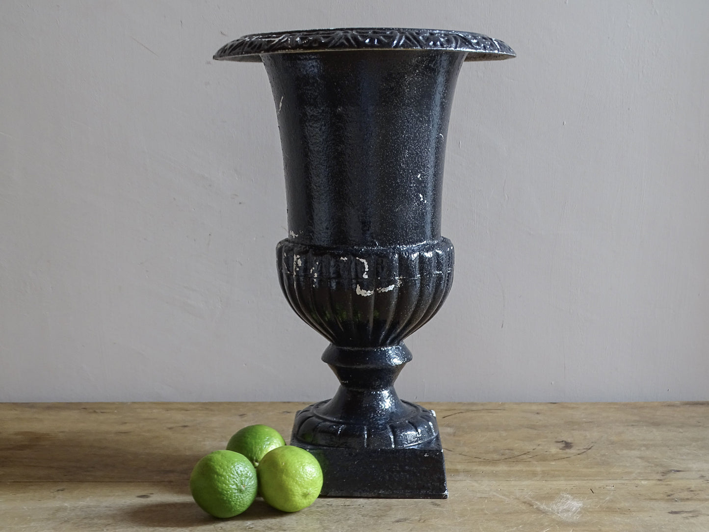 Antique French cast iron Médici urn planter with black painted finish, flared rim, gadrooned detail and square pedestal base.