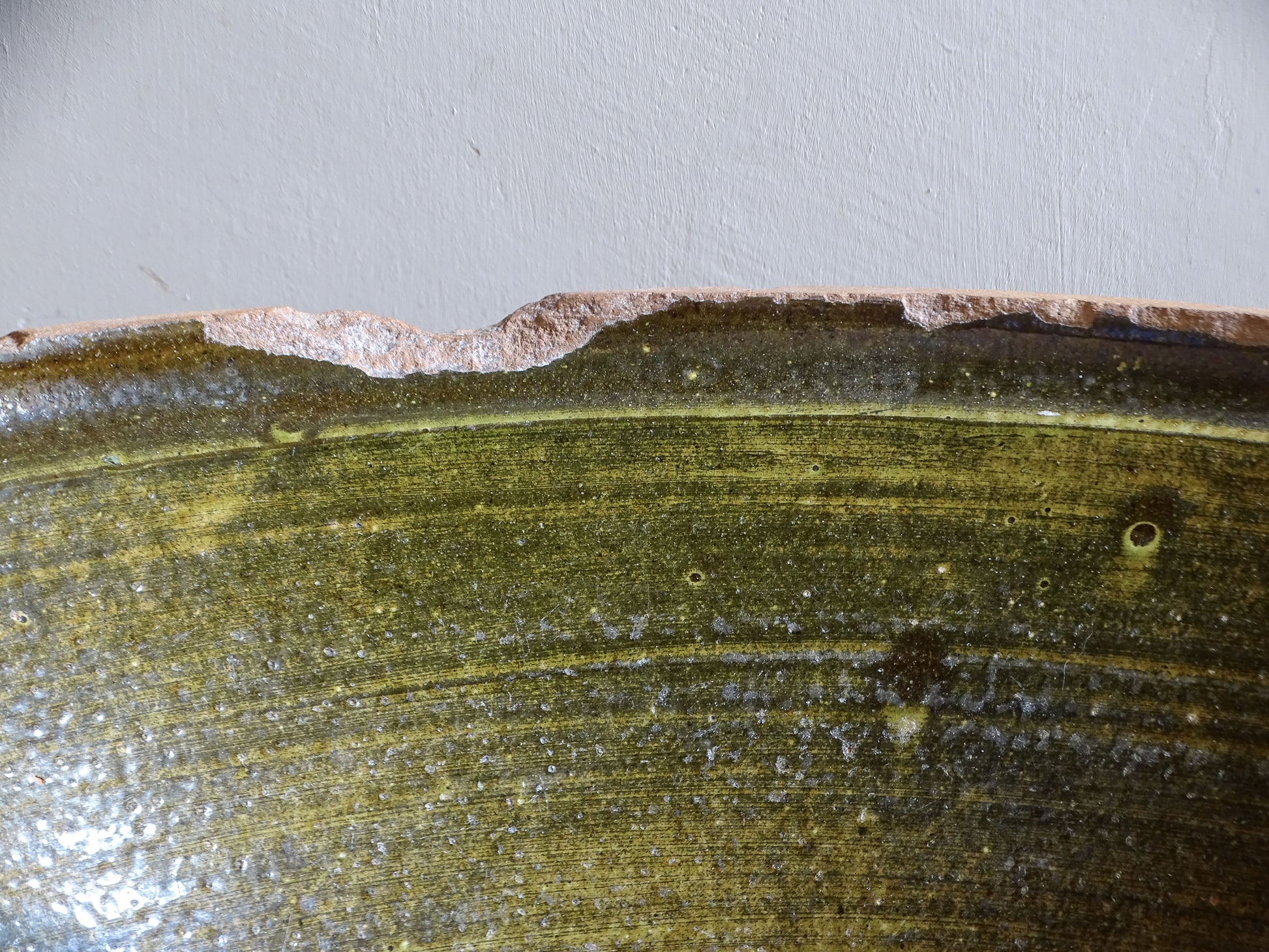 Large antique French tian bowl with dark olive-green glazed interior and unglazed terracotta exterior, early 20th century.