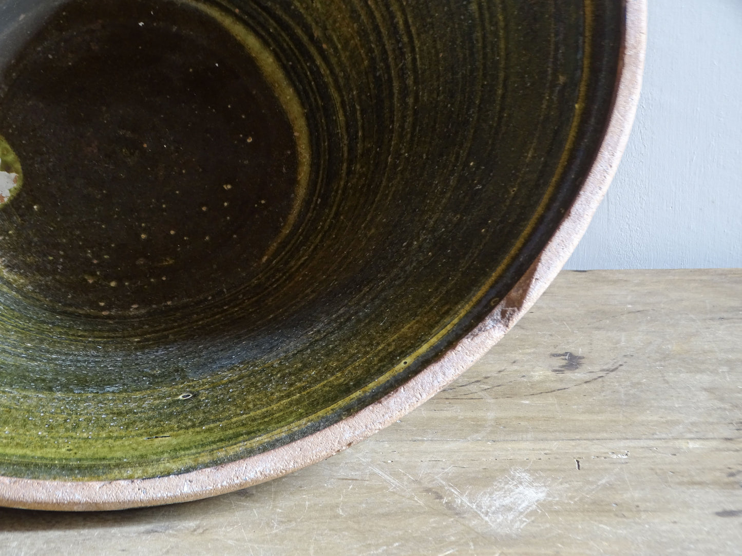 Large antique French tian bowl with dark olive-green glazed interior and unglazed terracotta exterior, early 20th century.