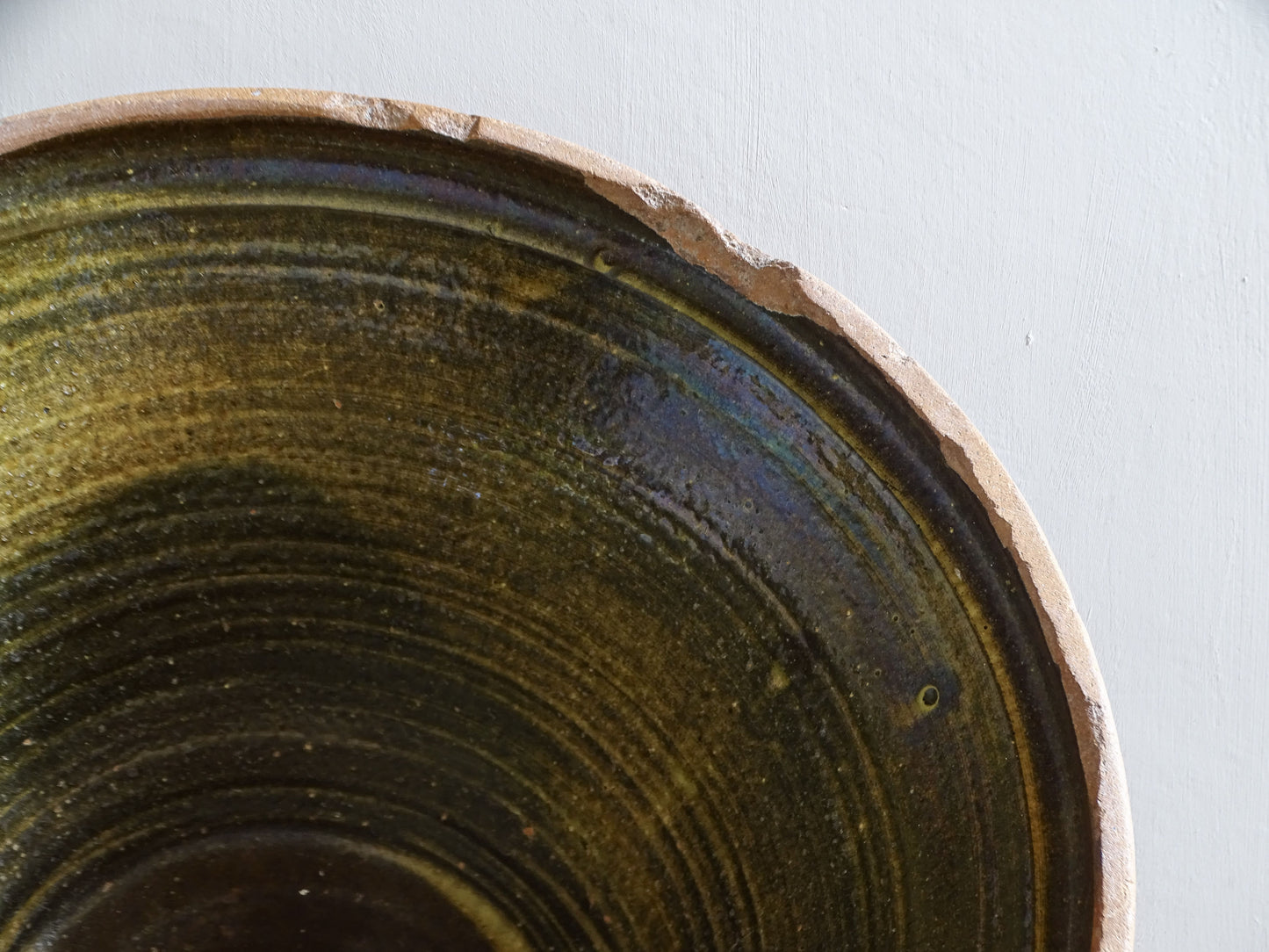 Large antique French tian bowl with dark olive-green glazed interior and unglazed terracotta exterior, early 20th century.