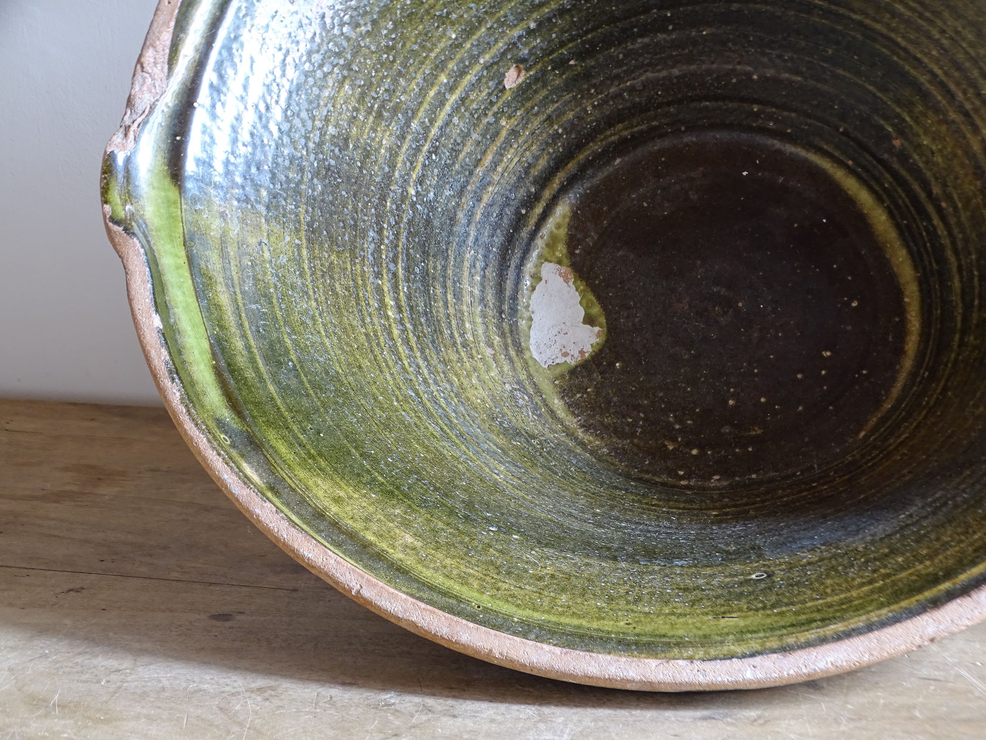 Large antique French tian bowl with dark olive-green glazed interior and unglazed terracotta exterior, early 20th century.