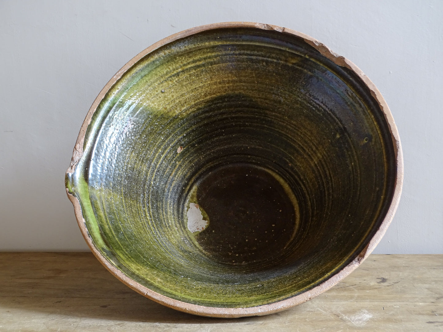 Large antique French tian bowl with dark olive-green glazed interior and unglazed terracotta exterior, early 20th century.