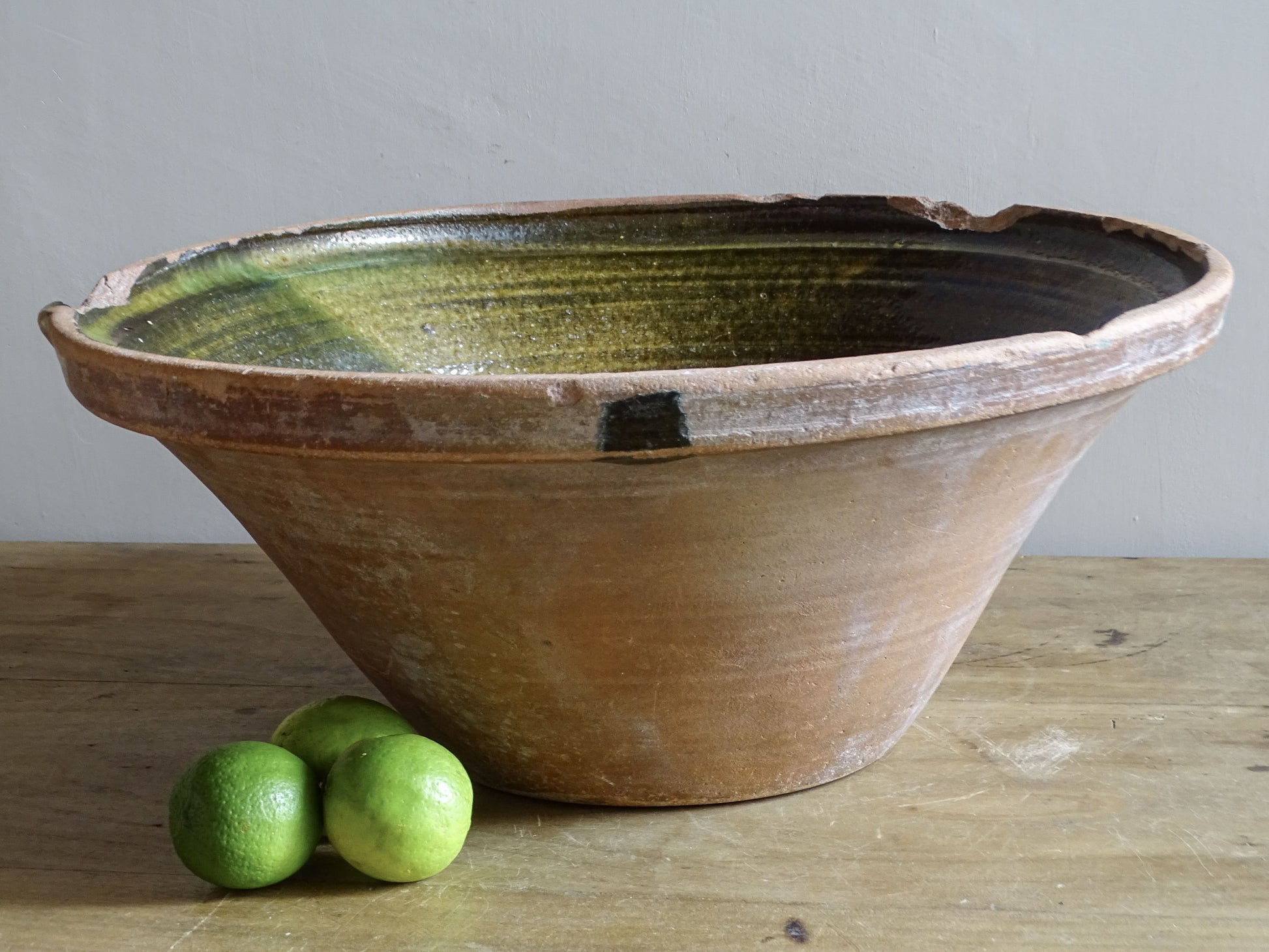 Large antique French tian bowl with dark olive-green glazed interior and unglazed terracotta exterior, early 20th century.