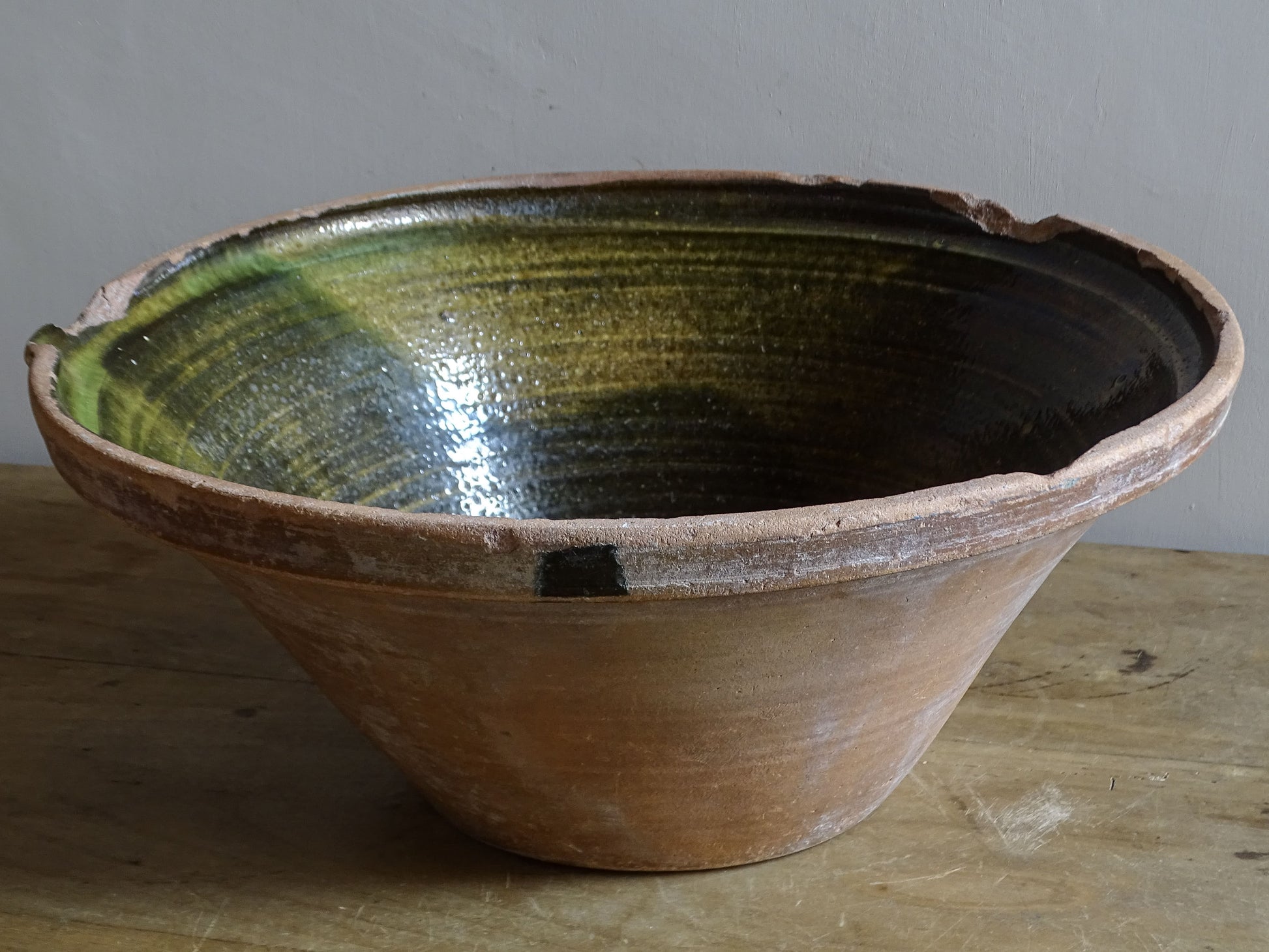 Large antique French tian bowl with dark olive-green glazed interior and unglazed terracotta exterior, early 20th century.