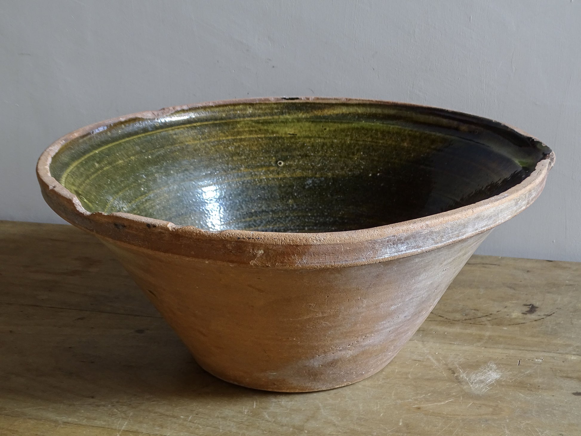 Large antique French tian bowl with dark olive-green glazed interior and unglazed terracotta exterior, early 20th century.