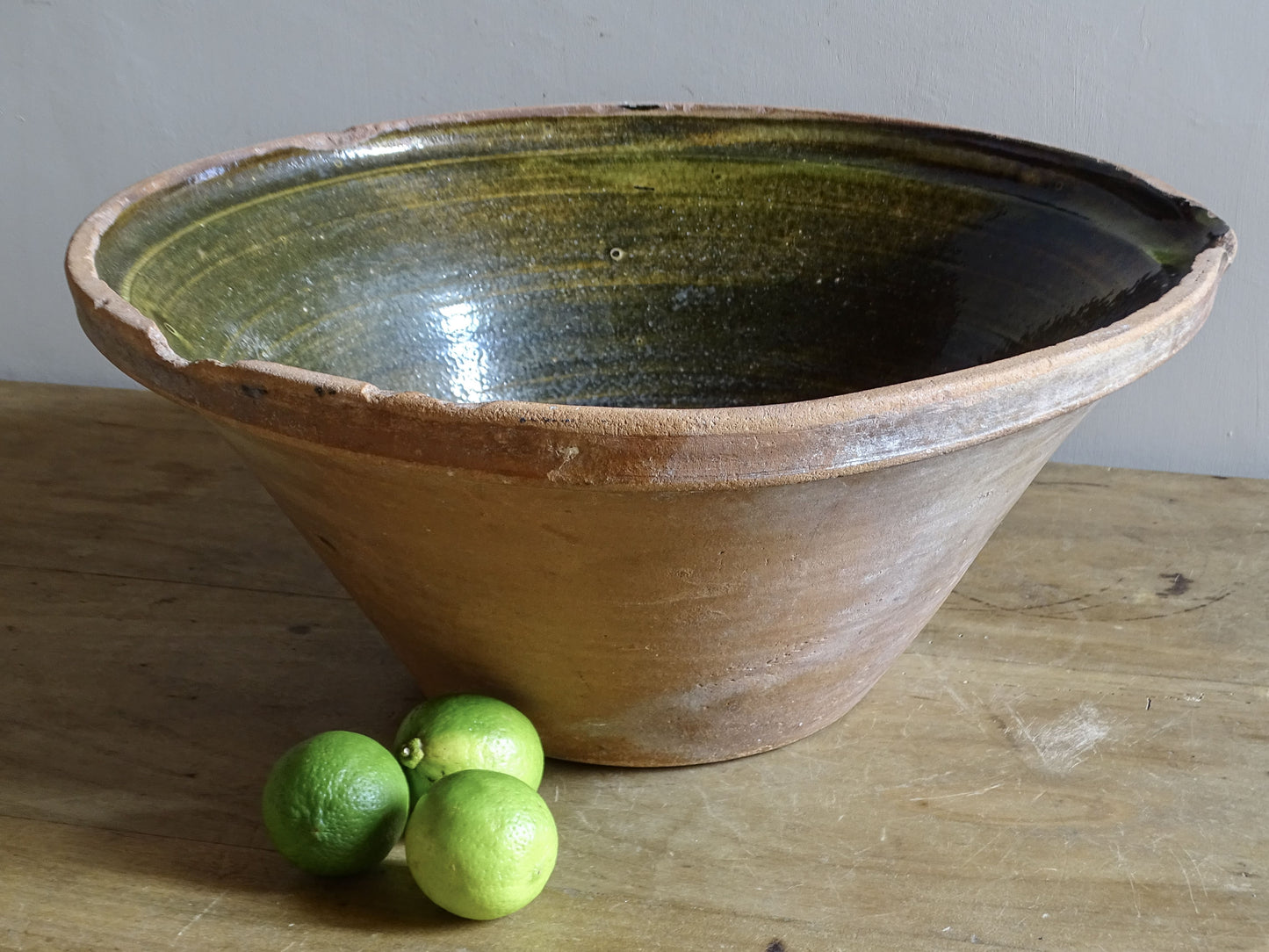 Large antique French tian bowl with dark olive-green glazed interior and unglazed terracotta exterior, early 20th century.