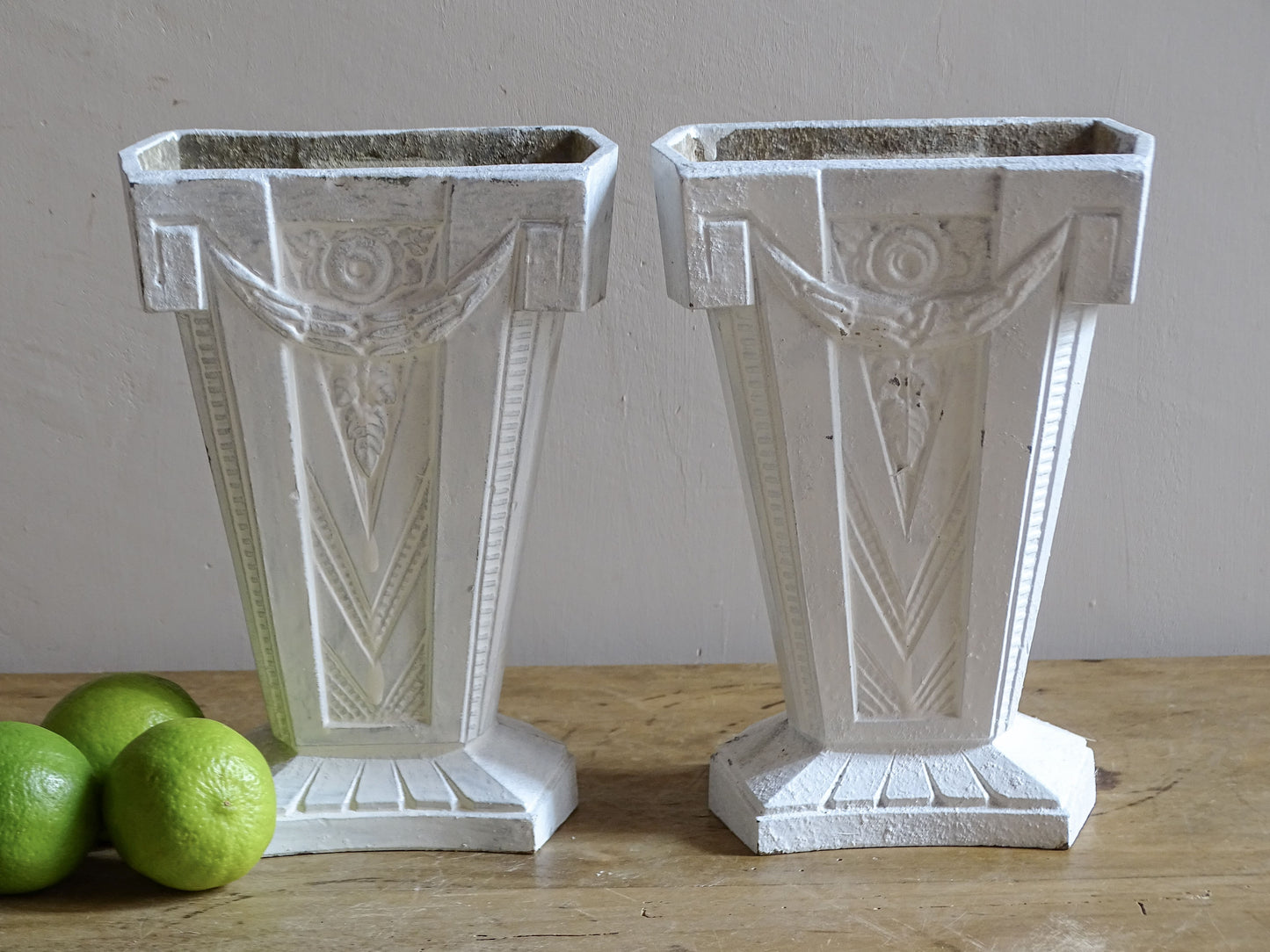 Pair of French Art Deco cast aluminium vases with white painted finish and geometric decoration.