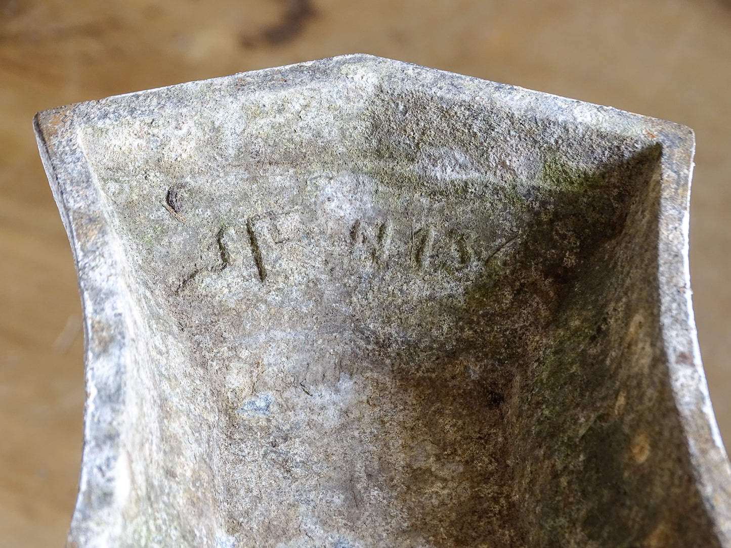 Close-up of the interior of a French Art Deco cast aluminium vase showing age-related patina and cast markings.