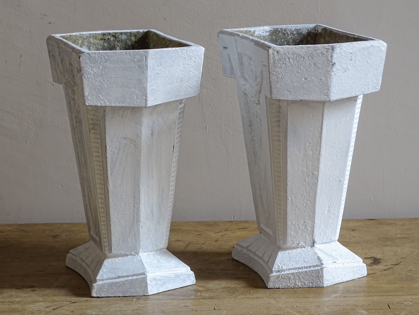 French Art Deco aluminium vases with architectural stepped bases and geometric moulded decoration.