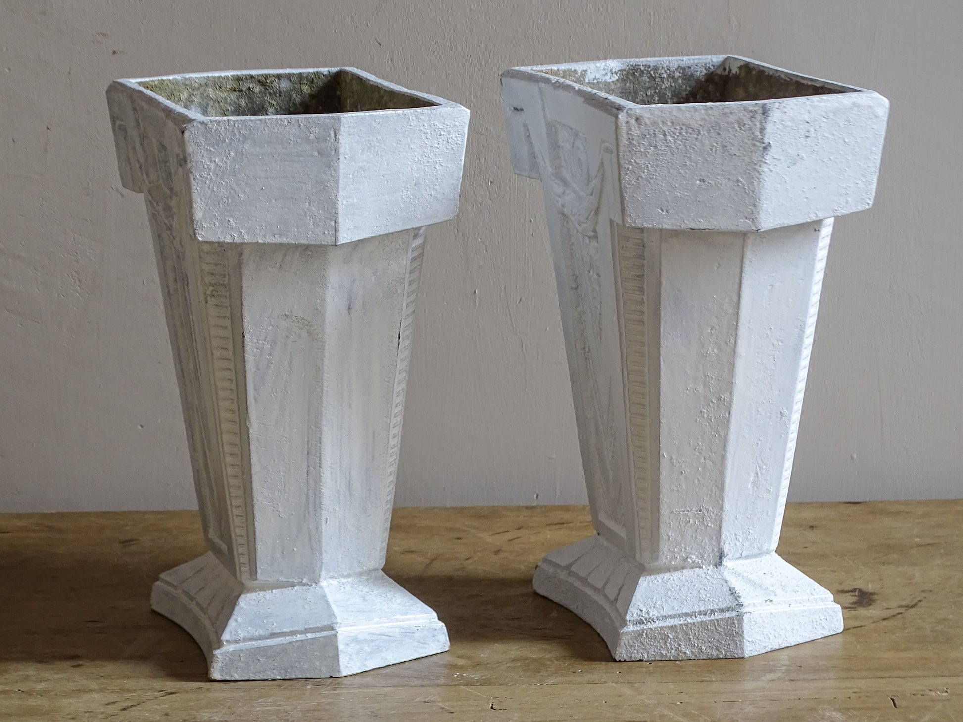 French Art Deco aluminium vases with architectural stepped bases and geometric moulded decoration.