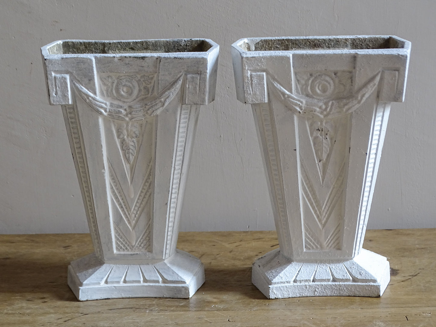 Pair of 1930s French Art Deco vases in white painted cast aluminium with decorative rosette and swag motifs.
