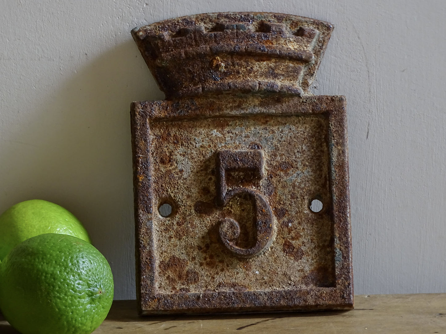 Vintage French cast iron house number plaque No. 5 from Beaumont-du-Périgord, Dordogne, with a weathered patina and crenellated crest.
