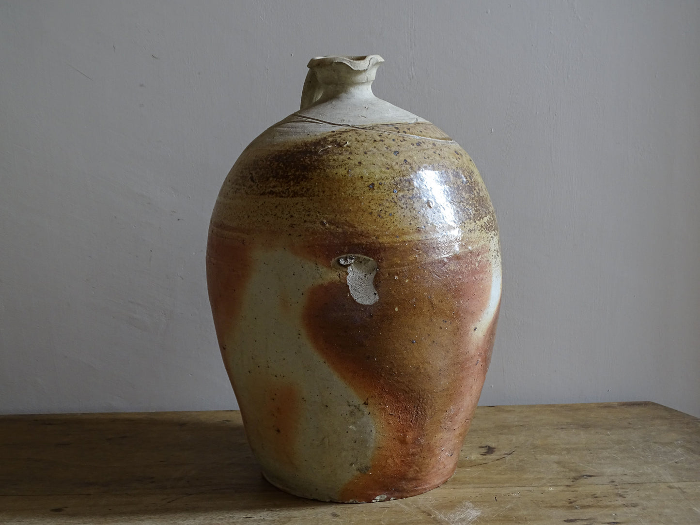Large decorative pottery jug with warm mottled surface