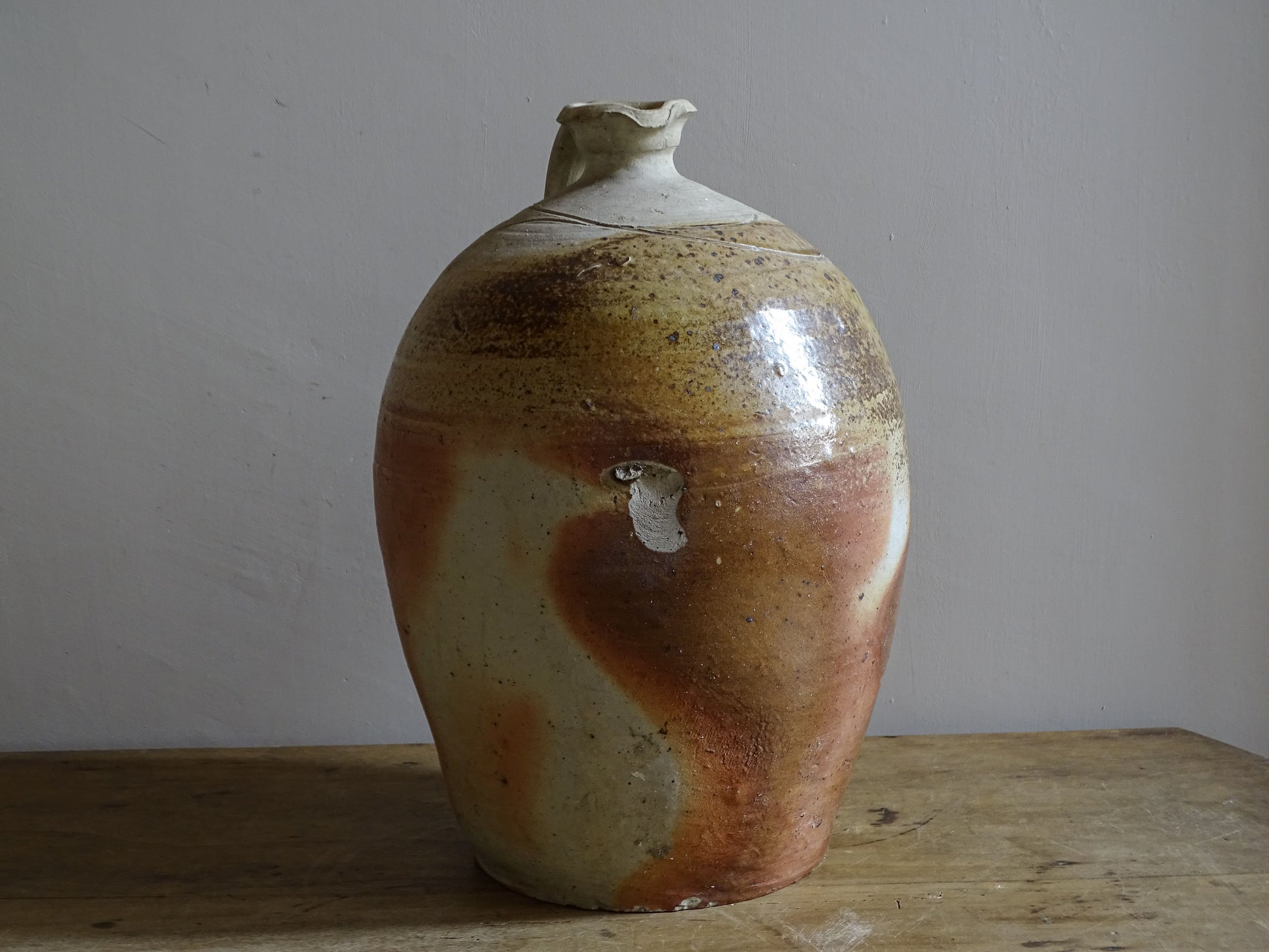 Large decorative pottery jug with warm mottled surface