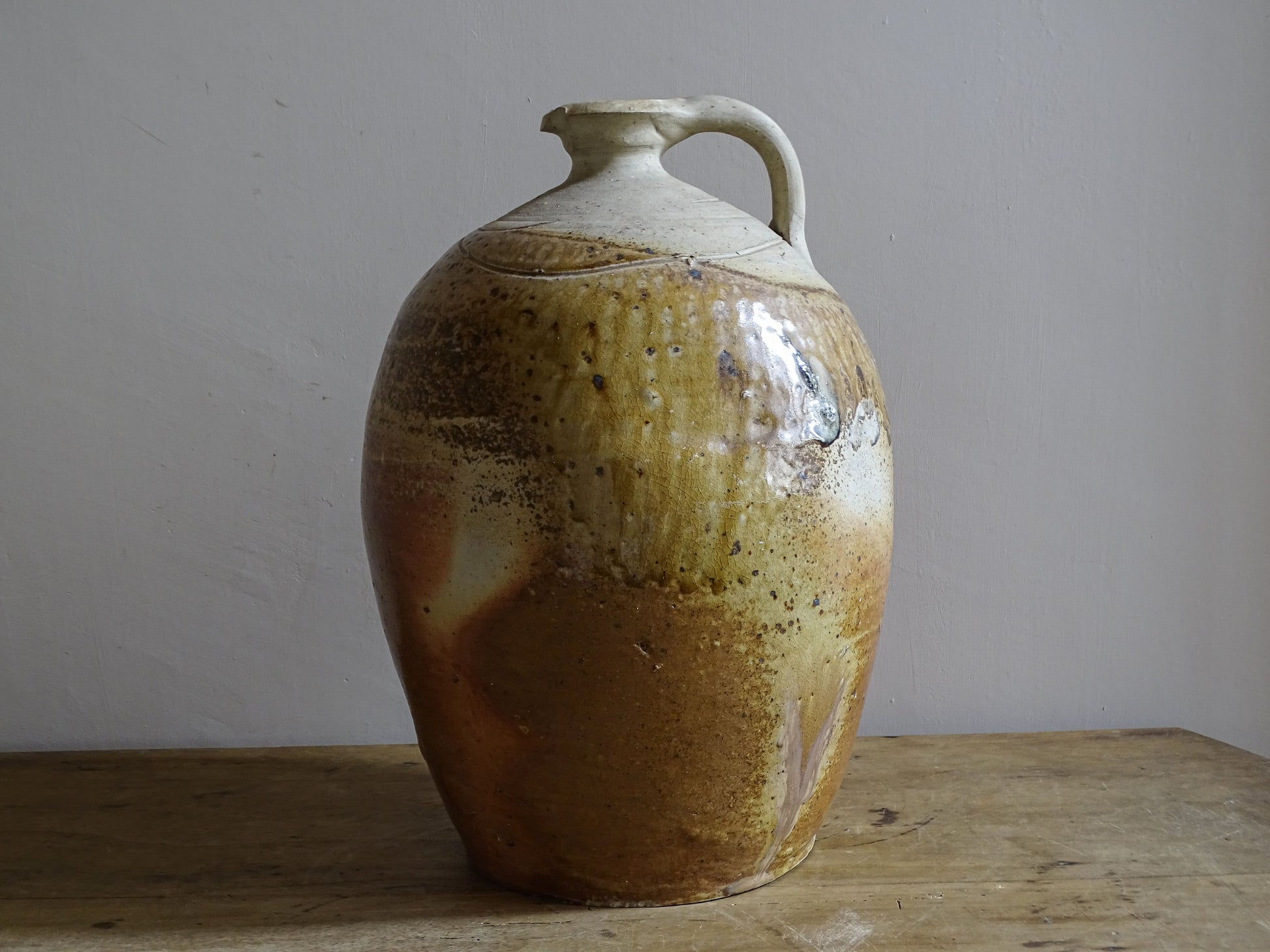 Rustic stoneware pitcher or cruche with hand-thrown form and varied glaze