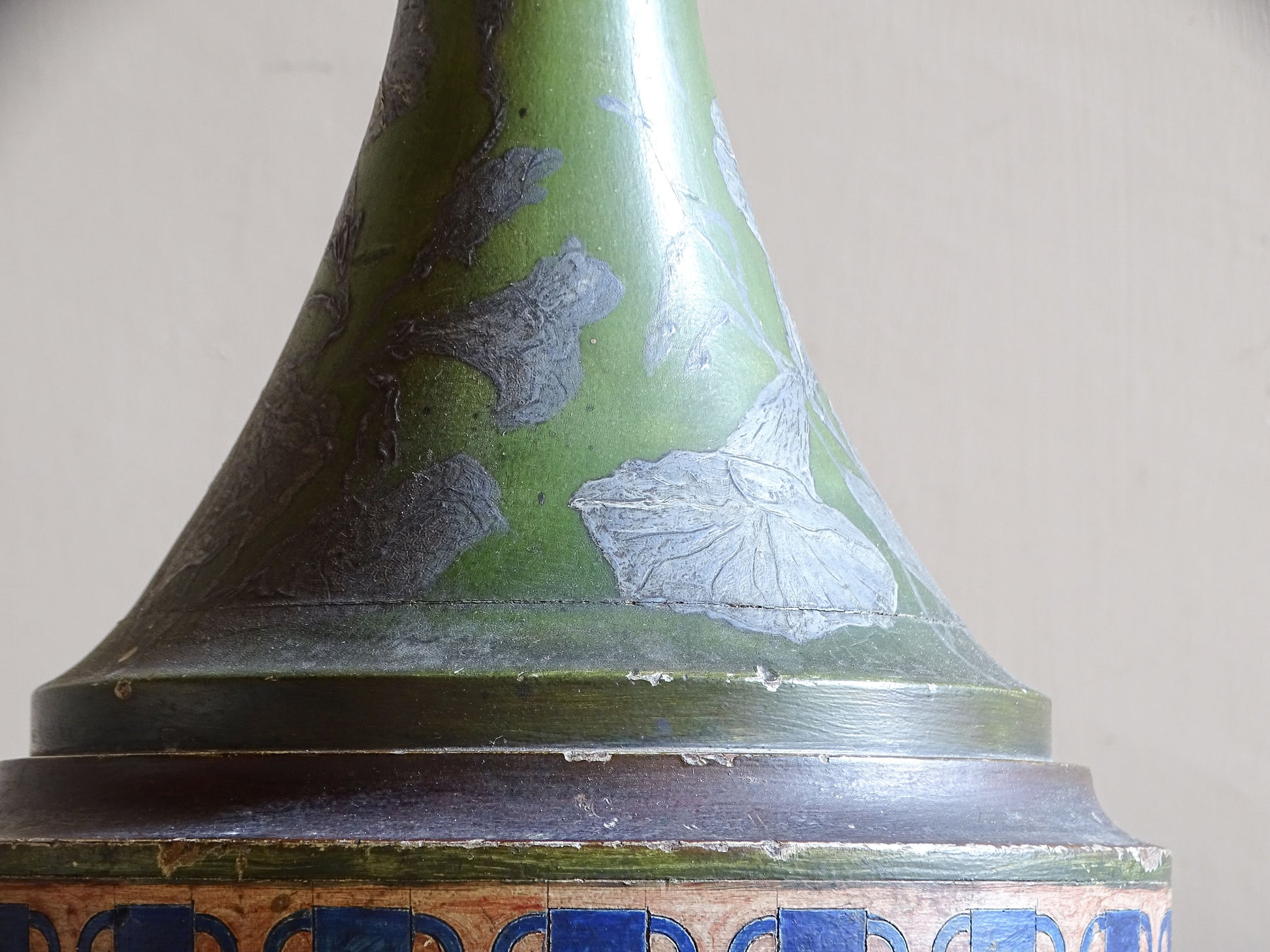Raised silver floral and foliate decoration on antique painted wooden lamp