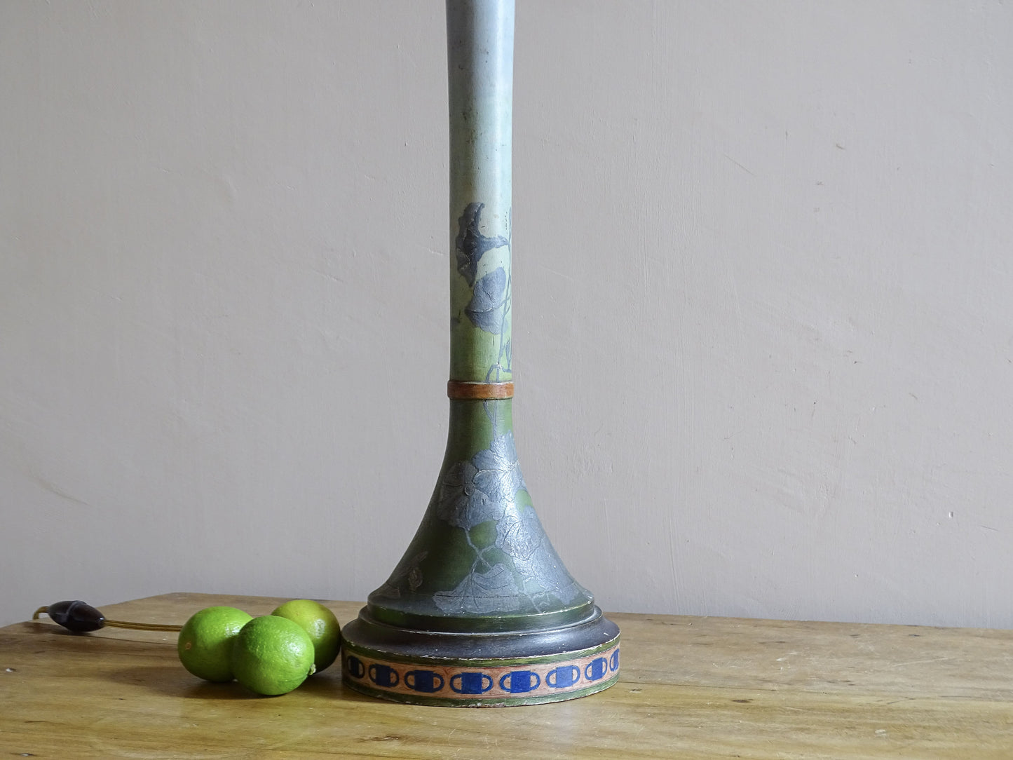 Close-up of raised silver flowers on green Art Nouveau painted wood lamp
